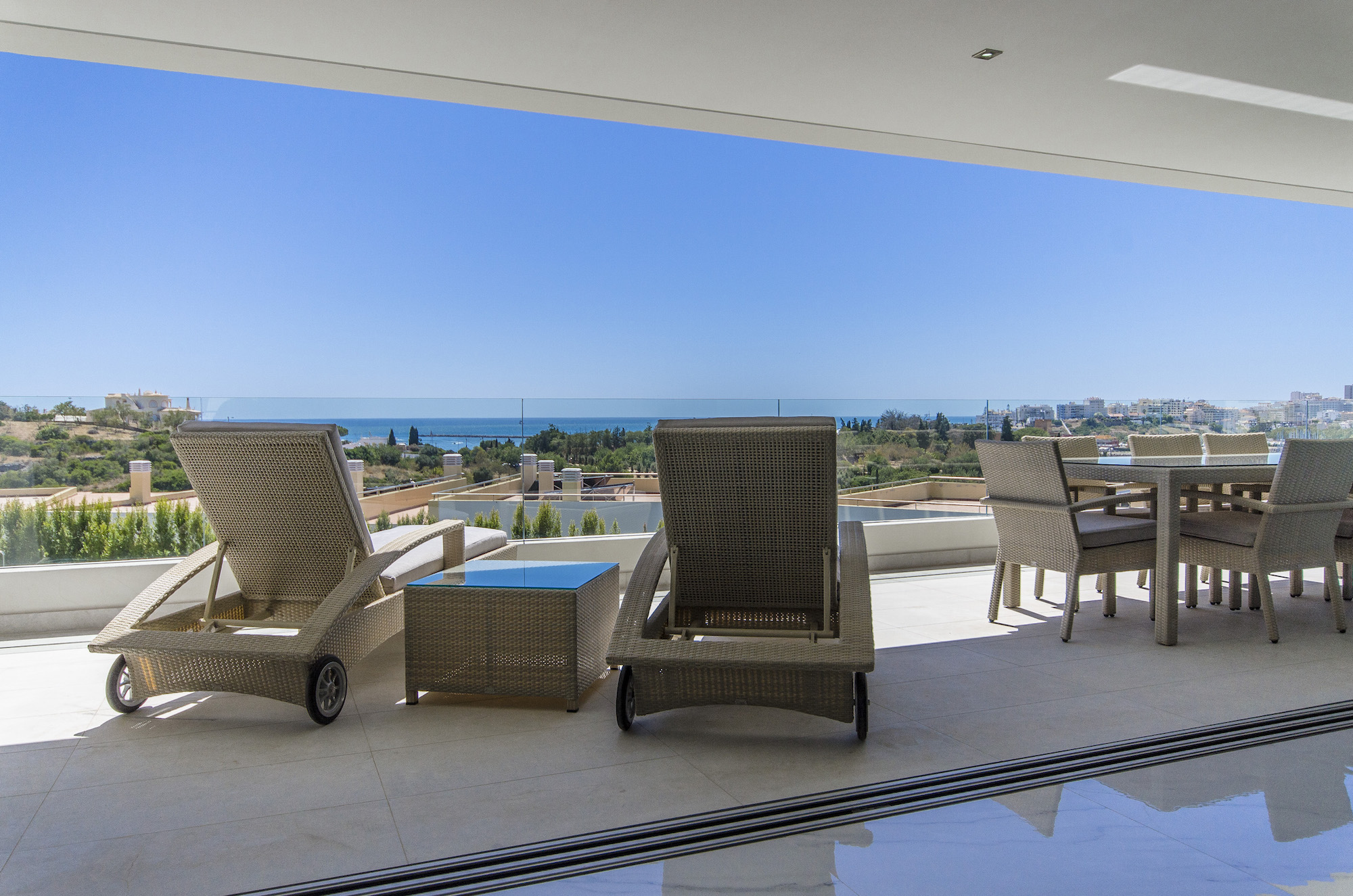 Sun-lit terrace of a luxury property with loungers overlooking the sea