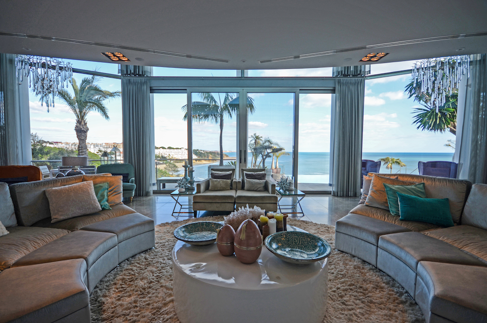 Living room of a luxury home with floor-to-ceiling windows over the sea