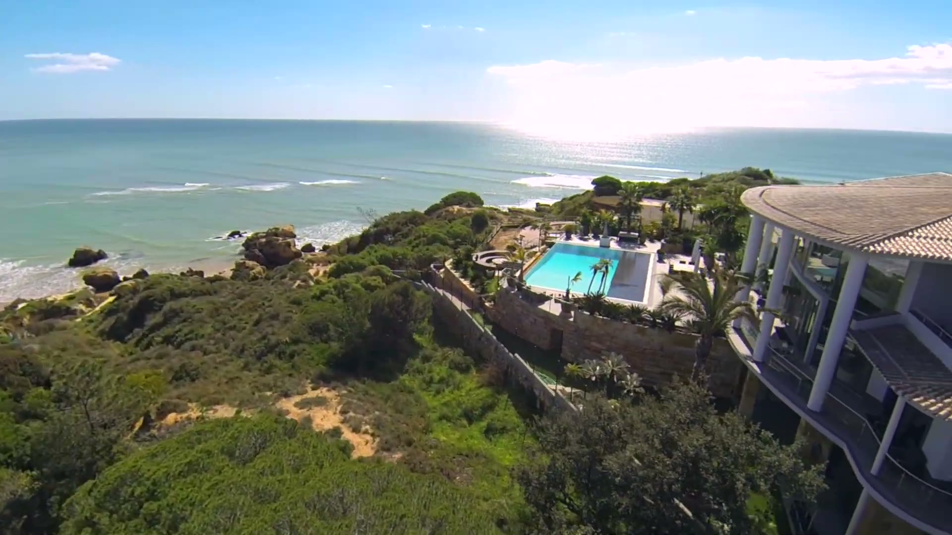 Aerial view of a clifftop luxury villa and pool above the Atlantic